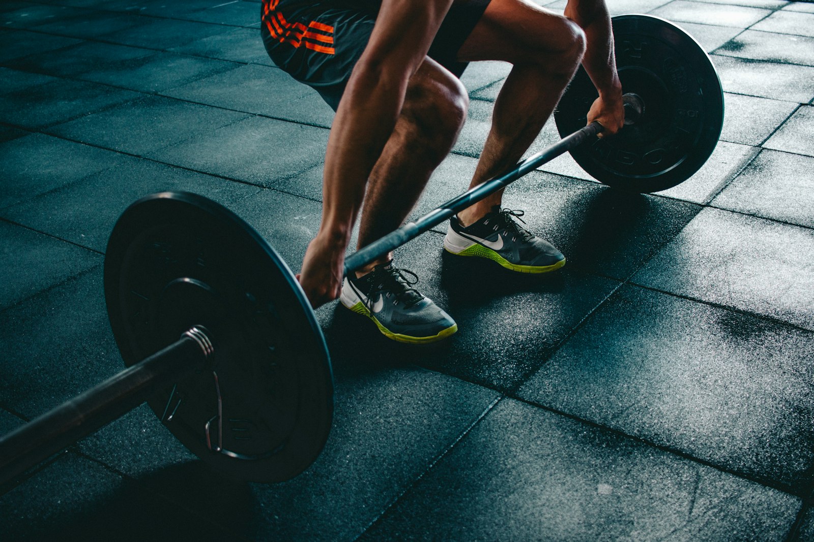 Deadlift setup with volt green shoes on a dark floor